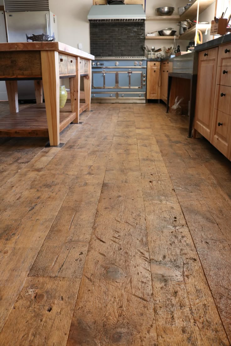 a large kitchen with wooden floors and cabinets