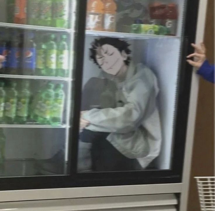 a man standing in front of a refrigerator filled with drinks