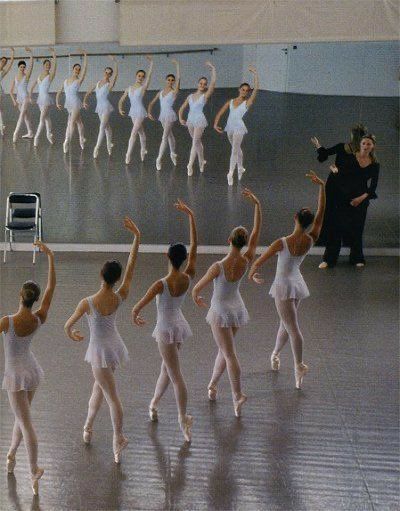 a group of ballerinas in white tutus and leotards with their arms raised