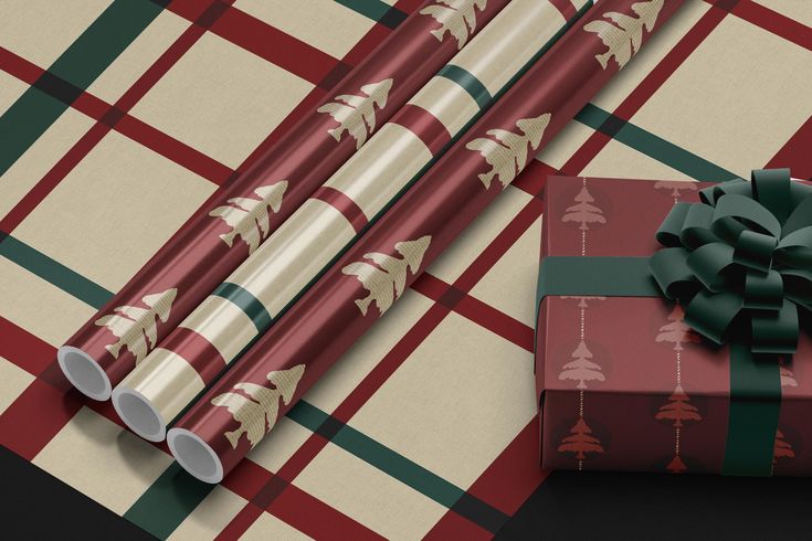 two wrapped presents sitting next to each other on a plaid tablecloth with bows and ribbons