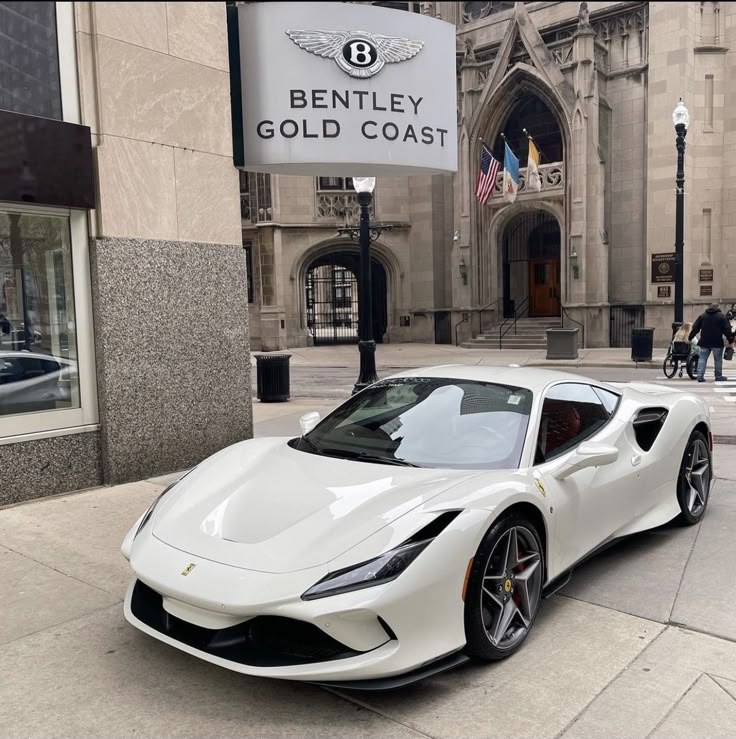 a white sports car parked in front of a building