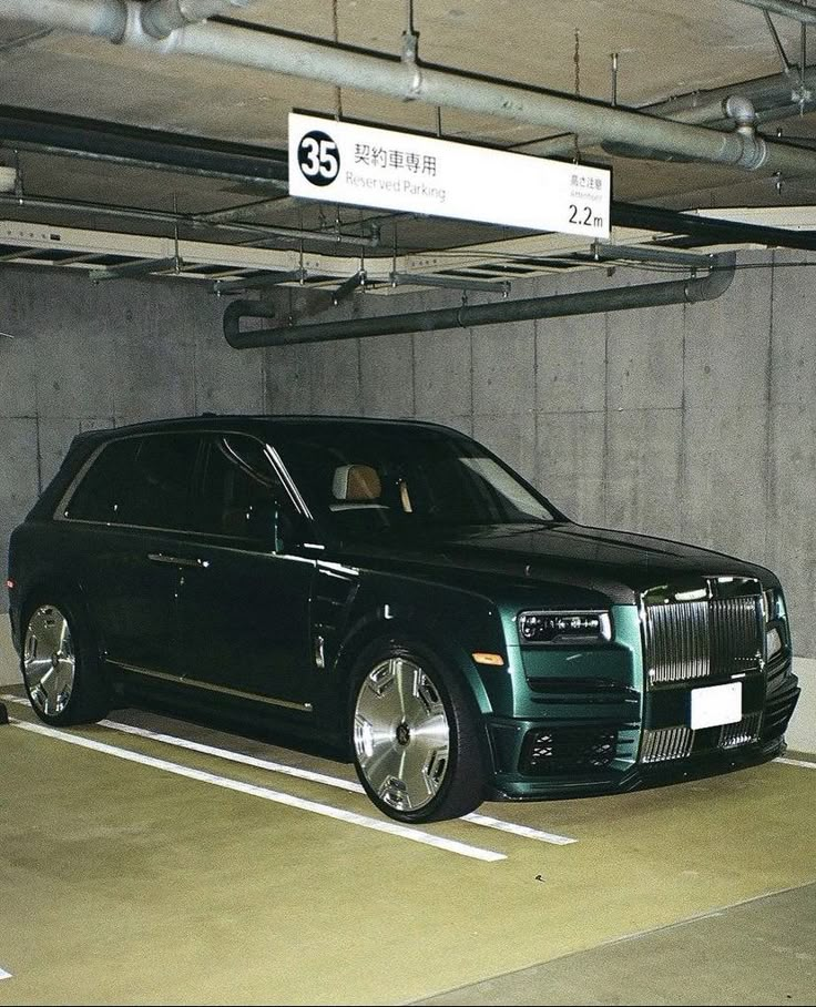 a black rolls royce parked in a parking garage