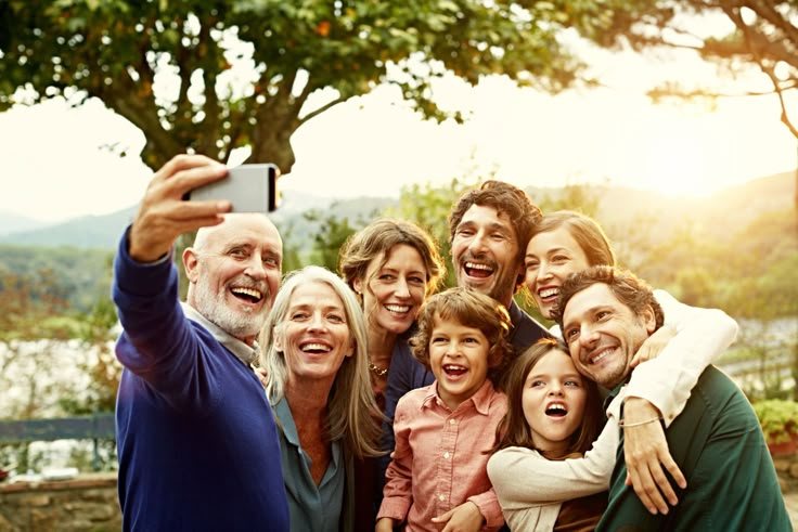 a group of people taking a selfie with a cell phone in front of them