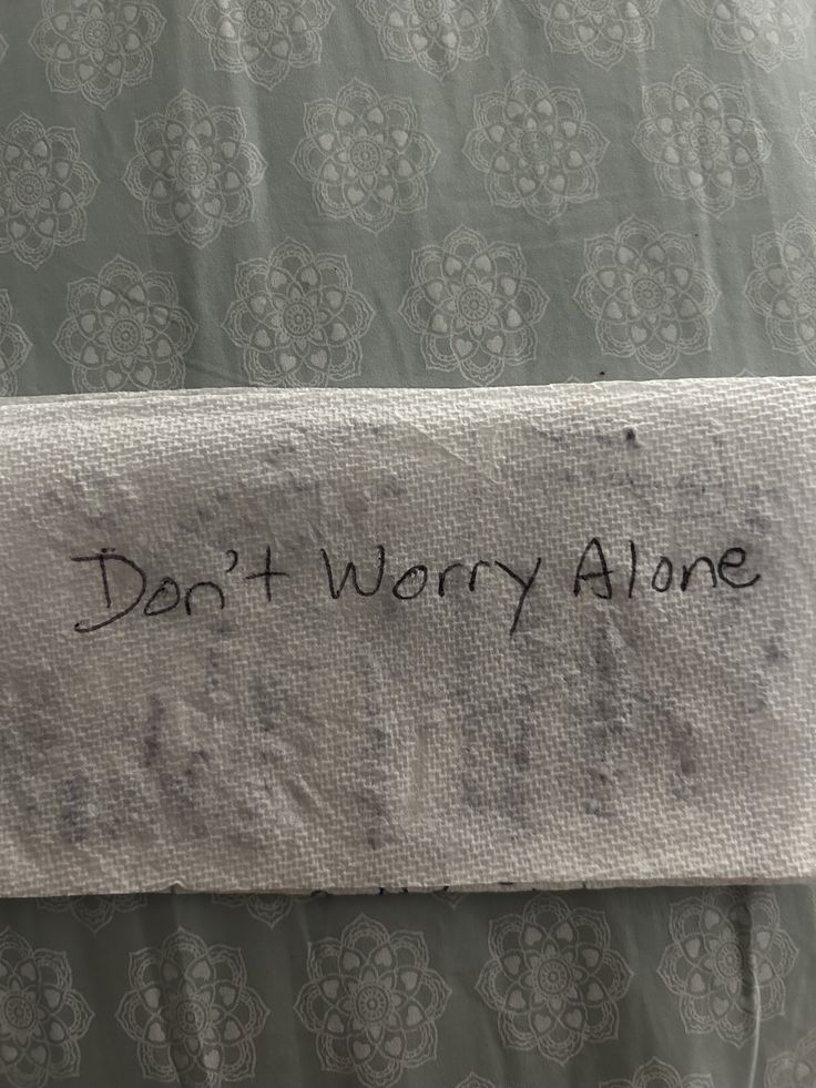 a piece of cloth with writing on it that says, don't worry alone