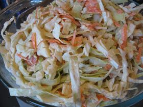 a glass bowl filled with coleslaw on top of a table