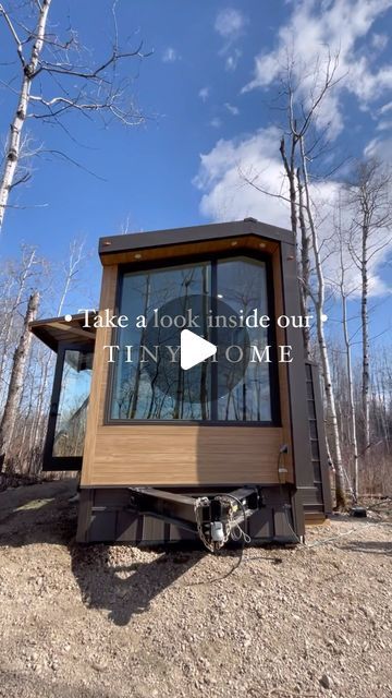 a tiny house sitting on top of a dirt field next to trees with the words take a look inside our tiny home