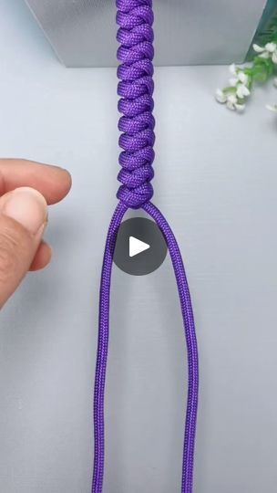 someone is holding a purple rope with one hand