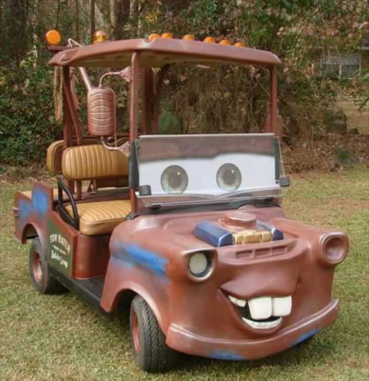 a toy car that is sitting in the grass with eyes on it's face