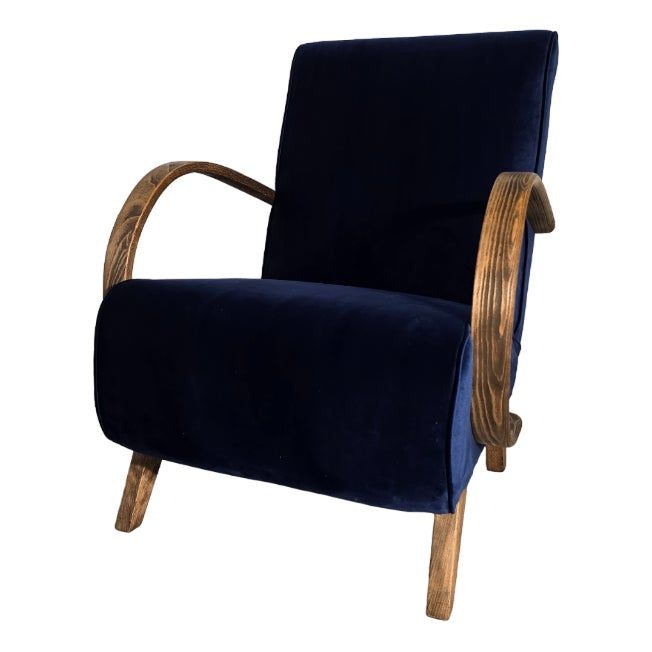 a blue velvet chair with wooden legs and arm rests on an isolated white background,