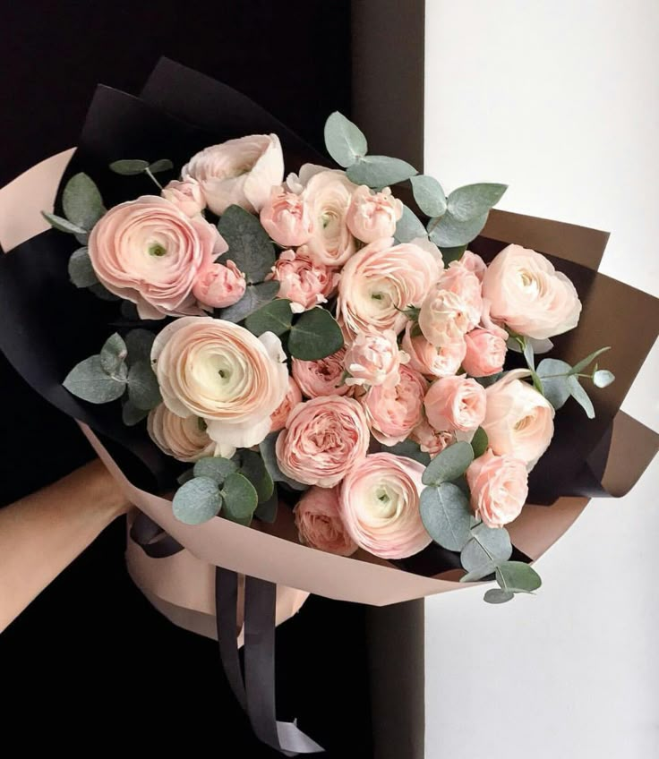 a person holding a bouquet of pink flowers