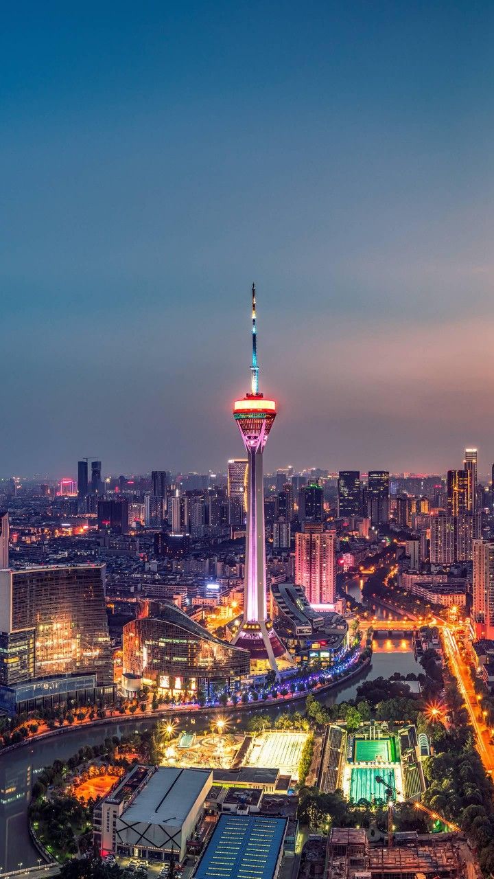 an aerial view of a city at night with the lights on and buildings lit up