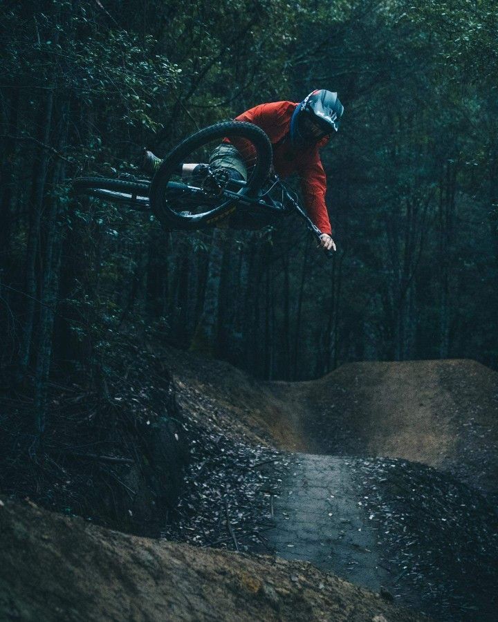 a man flying through the air while riding a bike