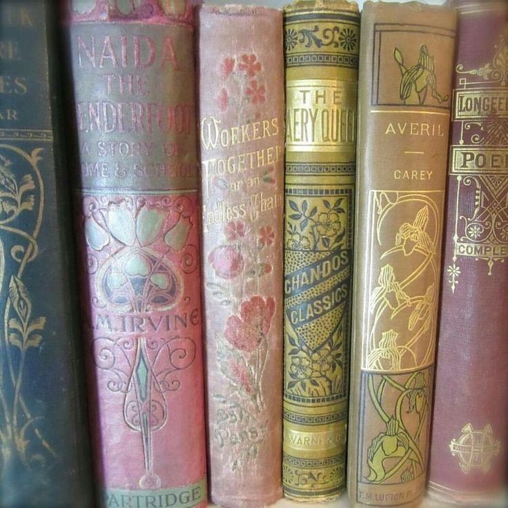 several old books are lined up on a shelf