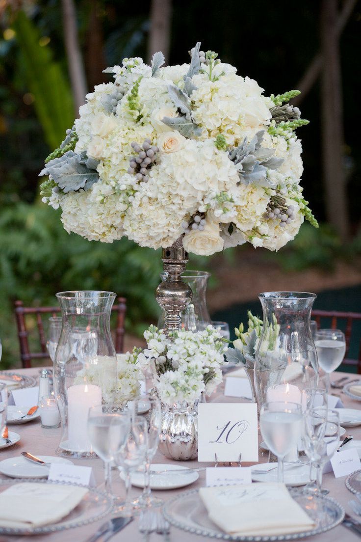 the centerpieces on this table are all white flowers