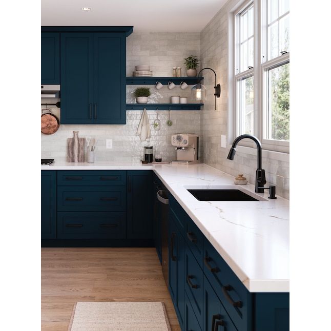 a kitchen with dark blue cabinets and white counter tops is seen in this image from the front view