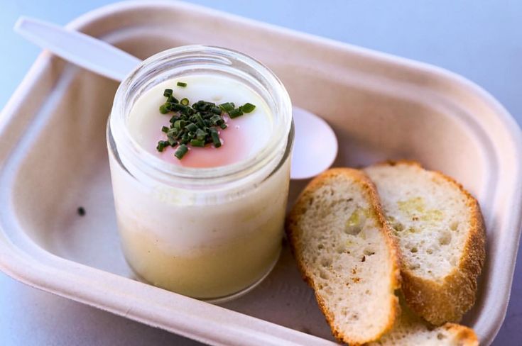 there is a small container with bread and yogurt in it