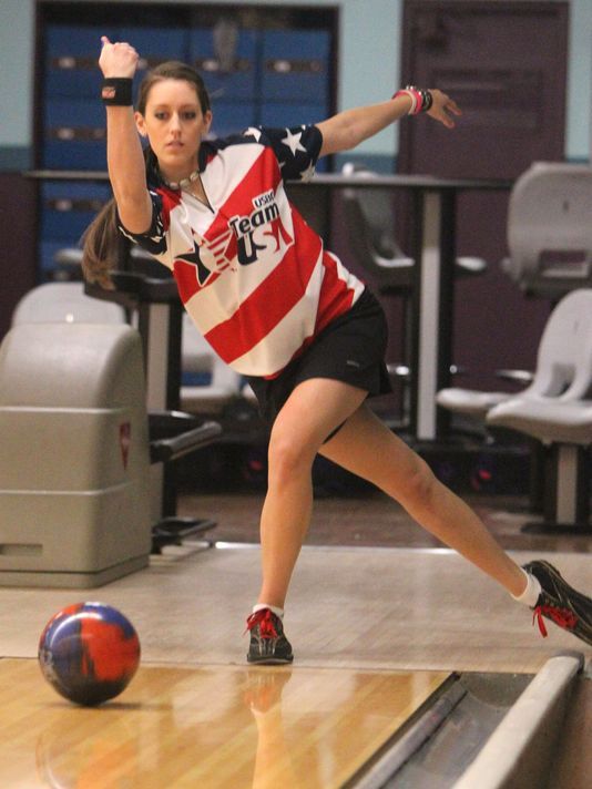 a young woman is bowling on the court