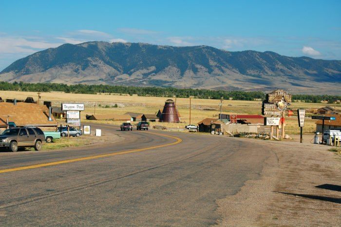 an old western town sits in the middle of a rural area with mountains in the background