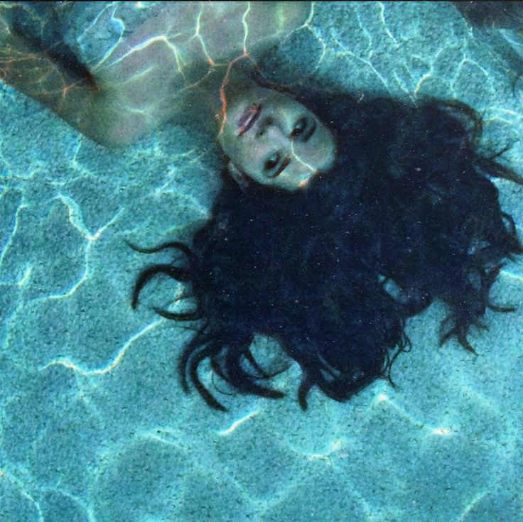 a woman with long hair laying on the ground