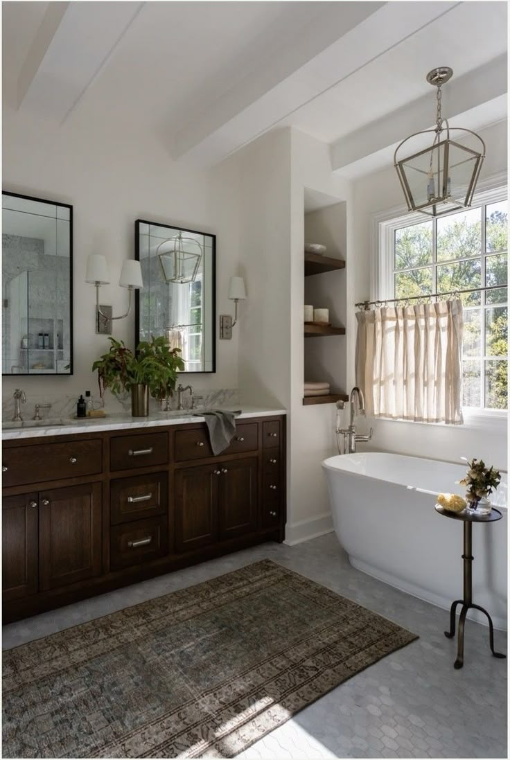 a bath room with a tub a mirror and a rug on the floor in front of it