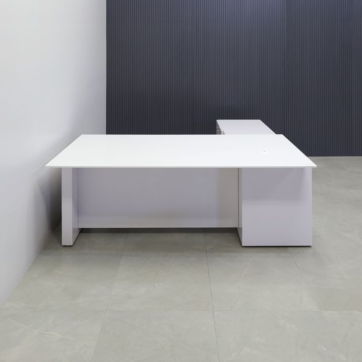 a white table sitting in the middle of a room next to a black and white wall