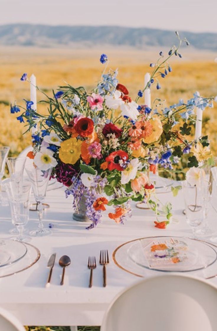 the table is set with flowers and candles