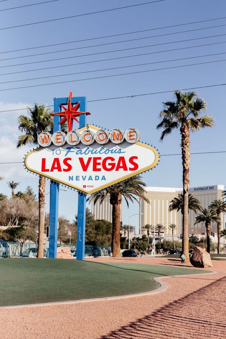 the welcome to las vegas sign in front of palm trees