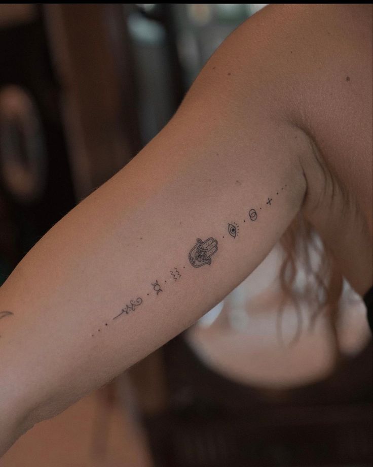 a woman's arm with the word love written in small stars and planets on it