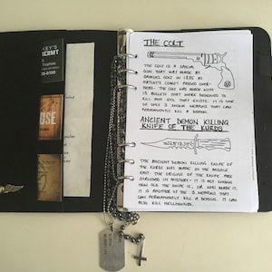 an open book with a key hanging from it