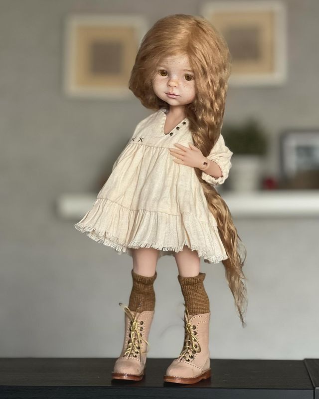 a doll with long hair and boots on top of a table