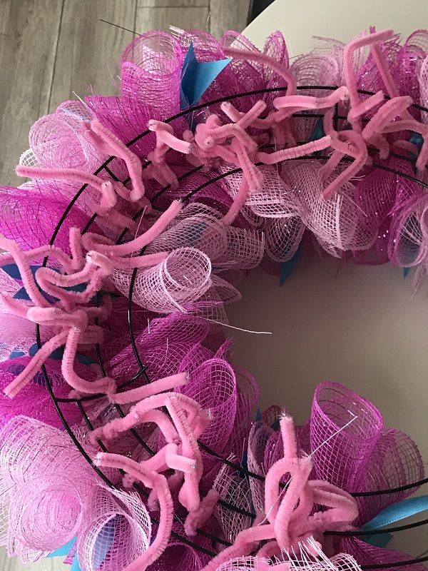 a pink and blue mesh wreath on top of a table