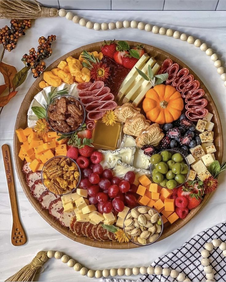 a platter filled with lots of different types of cheese and meats on top of a table