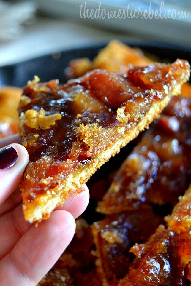 a person holding up a piece of food with jelly on it's side in front of a frying pan