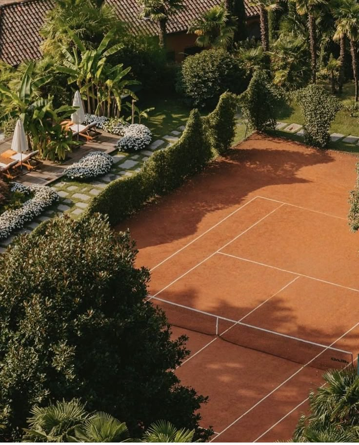 an aerial view of a tennis court surrounded by trees