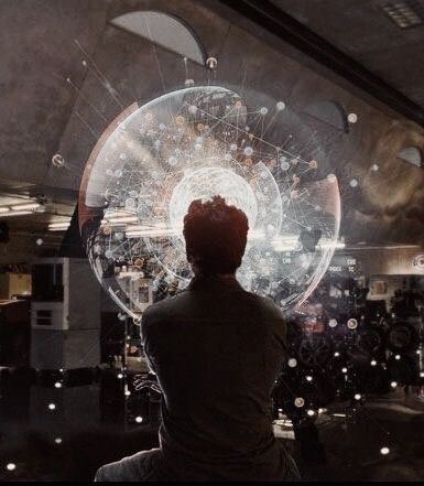 a man sitting in front of a large circular object