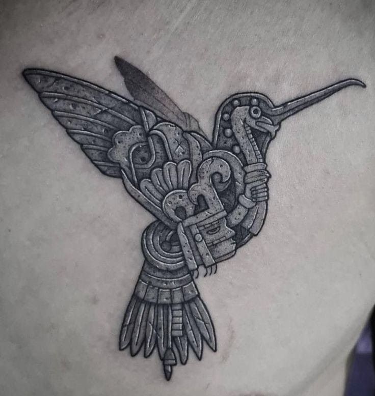 a black and white tattoo on the back of a woman's stomach with a hummingbird