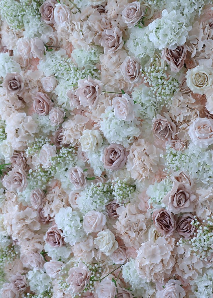 an arrangement of pink and white flowers arranged on top of each other in the shape of a wall