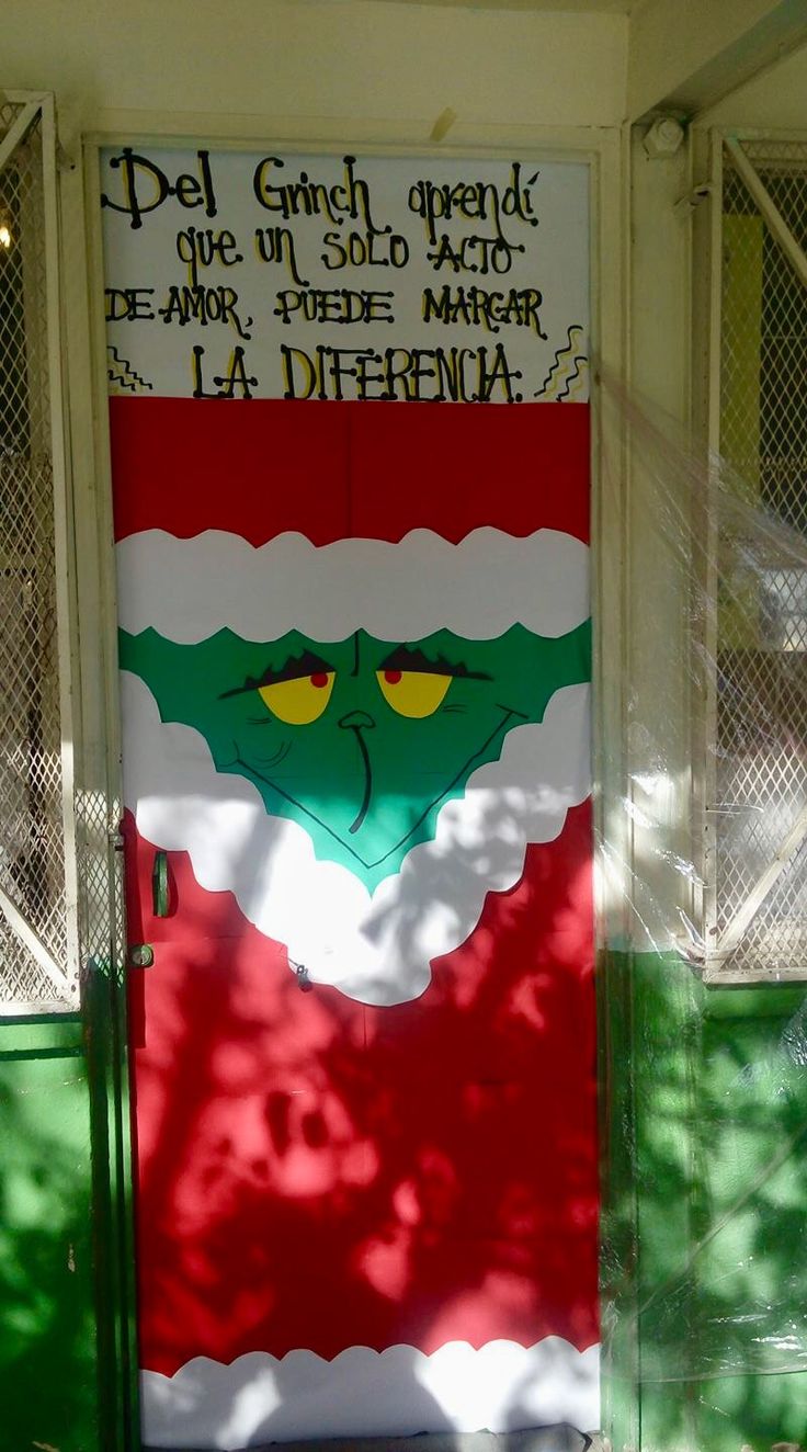 a green door with a red and white banner on it's side that says del grinch opera