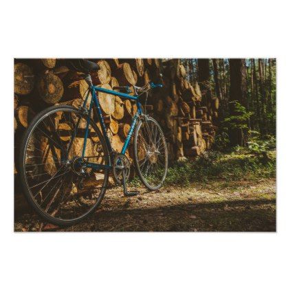 a blue bicycle parked next to a pile of logs