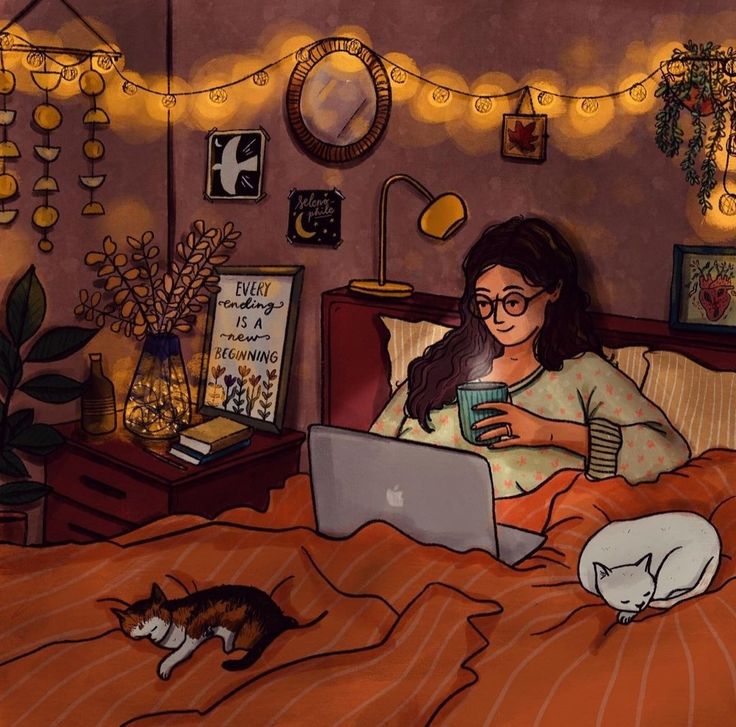 a woman laying in bed with her laptop and two cats