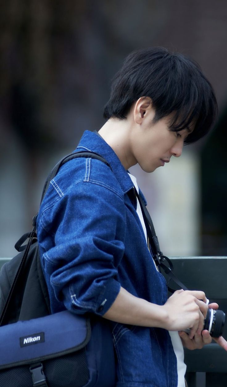 a young man is looking at his cell phone