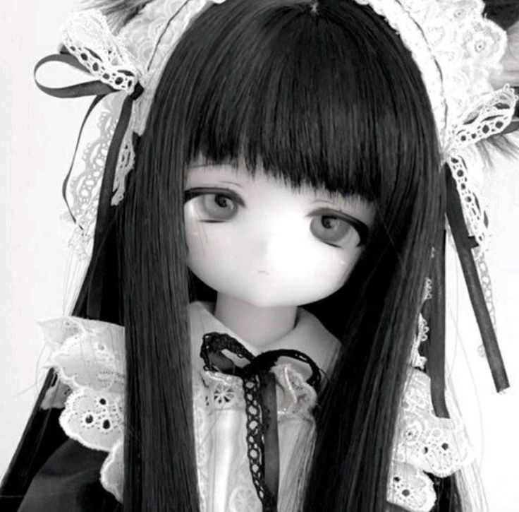 a black and white photo of a doll with long hair