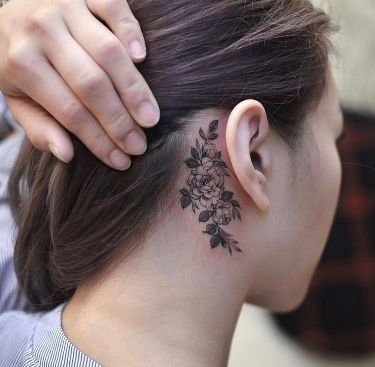 a woman with a flower tattoo on her neck