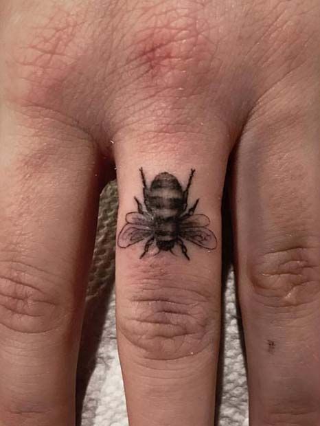 a small bee tattoo on the left hand and right hand finger tattoos for men and women