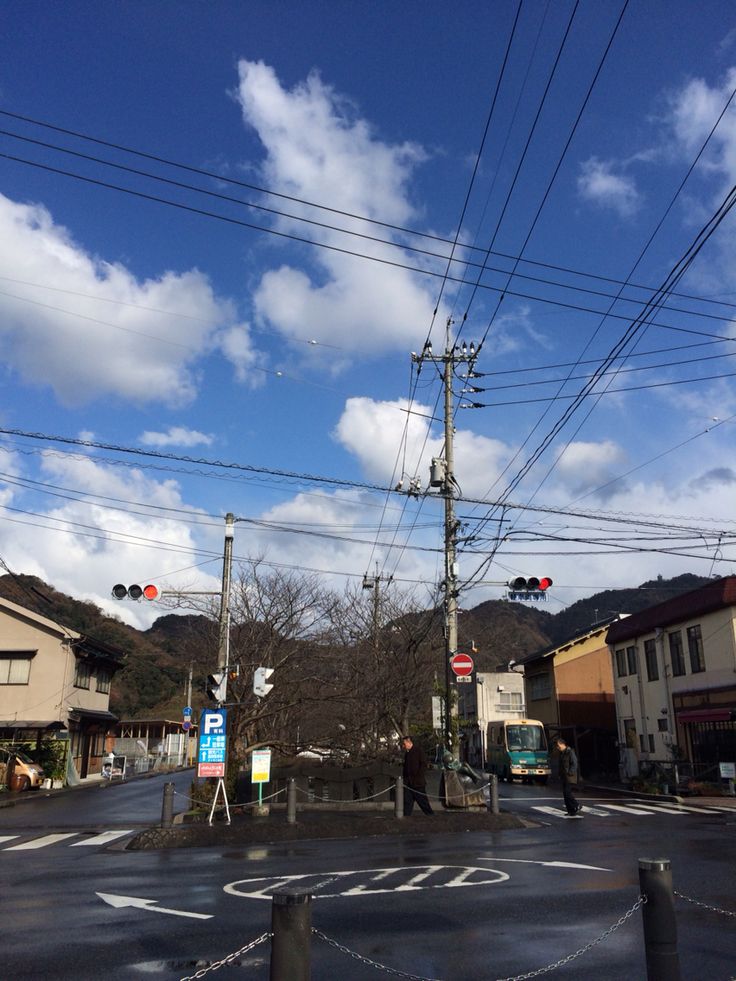 an intersection with traffic lights and power lines in the background, on a sunny day