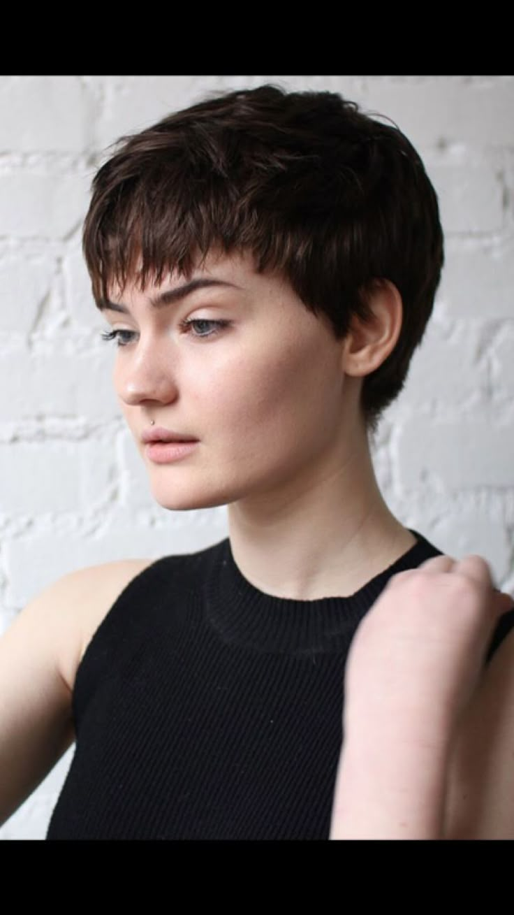 a close up of a person wearing a black shirt and holding something in her hand