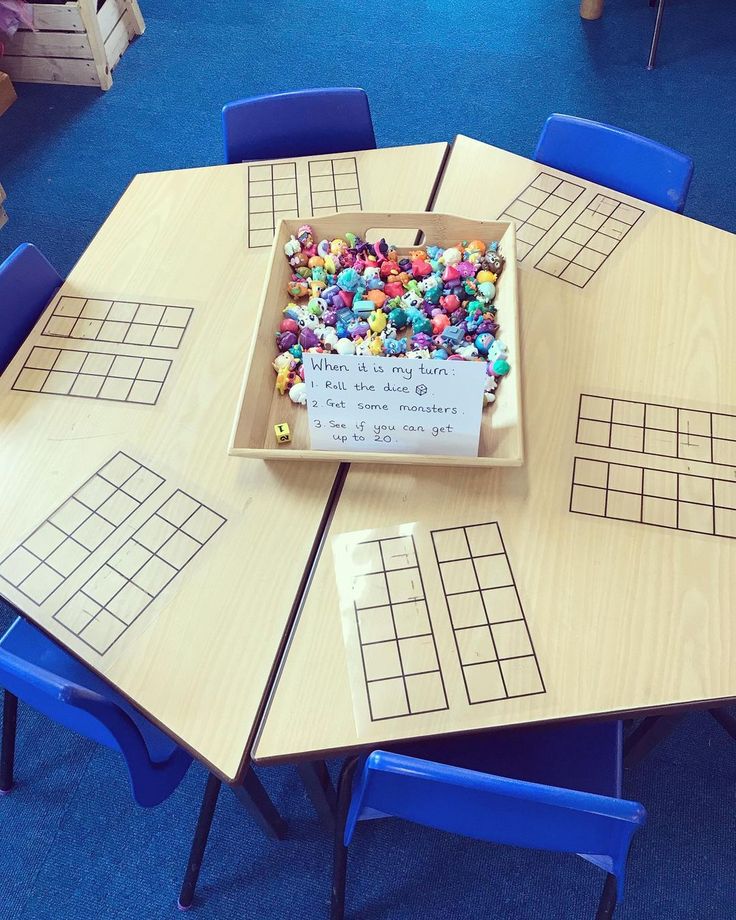 a wooden table topped with a cake covered in sprinkles next to blue chairs