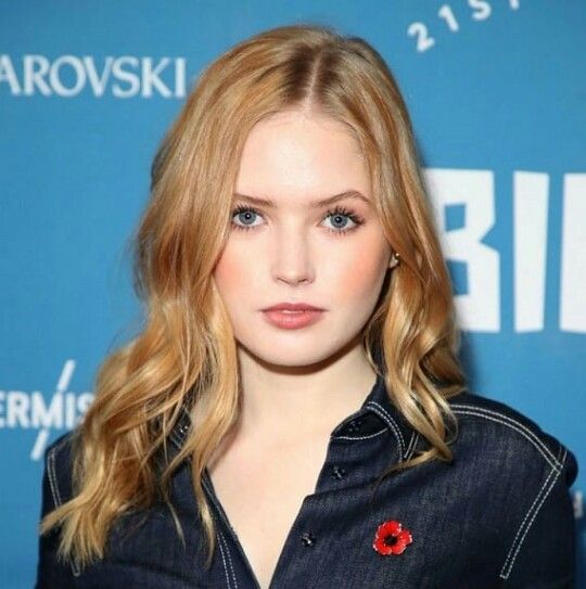 a woman with blonde hair and blue eyes posing for the camera