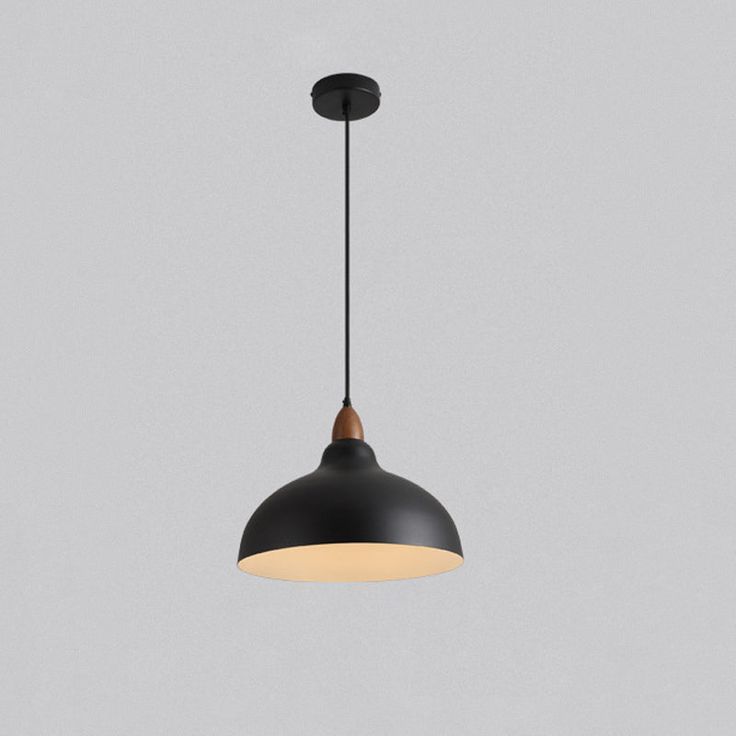 a black and white light hanging from a ceiling fixture on a gray wall with a grey background