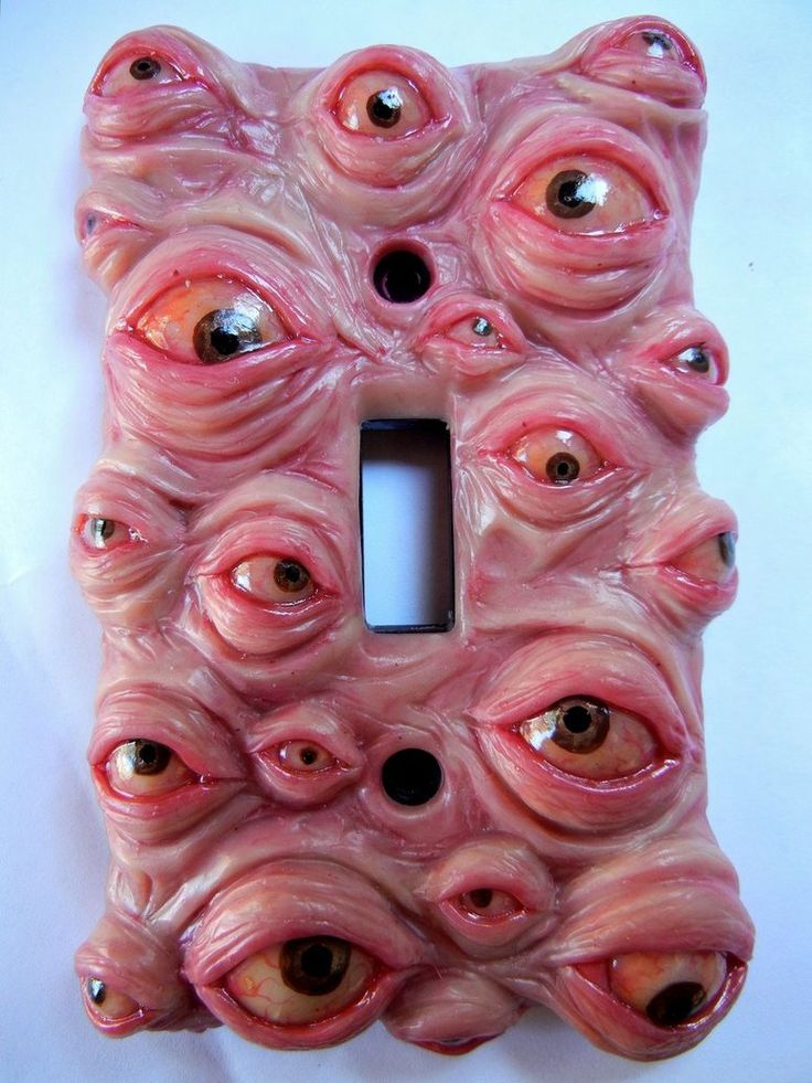 a pink light switch cover with eyes on it